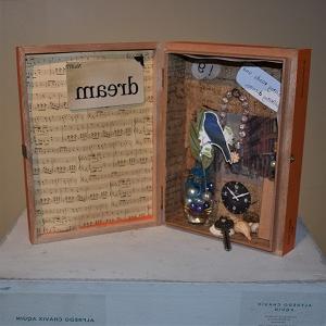 A box opened like a book with elements such as a music sheet, the word 